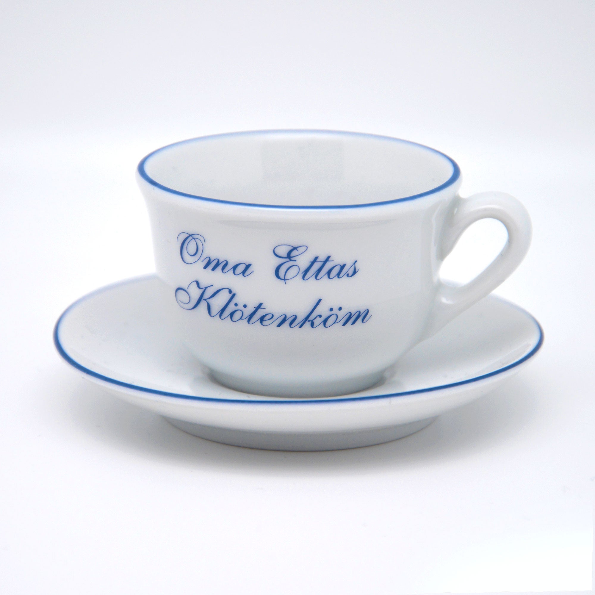 Selbstgemachte Oma Ettas Kloetenkoem Porzellan Tasse mit Untertasse fotografiert vor weißem Hintergrund